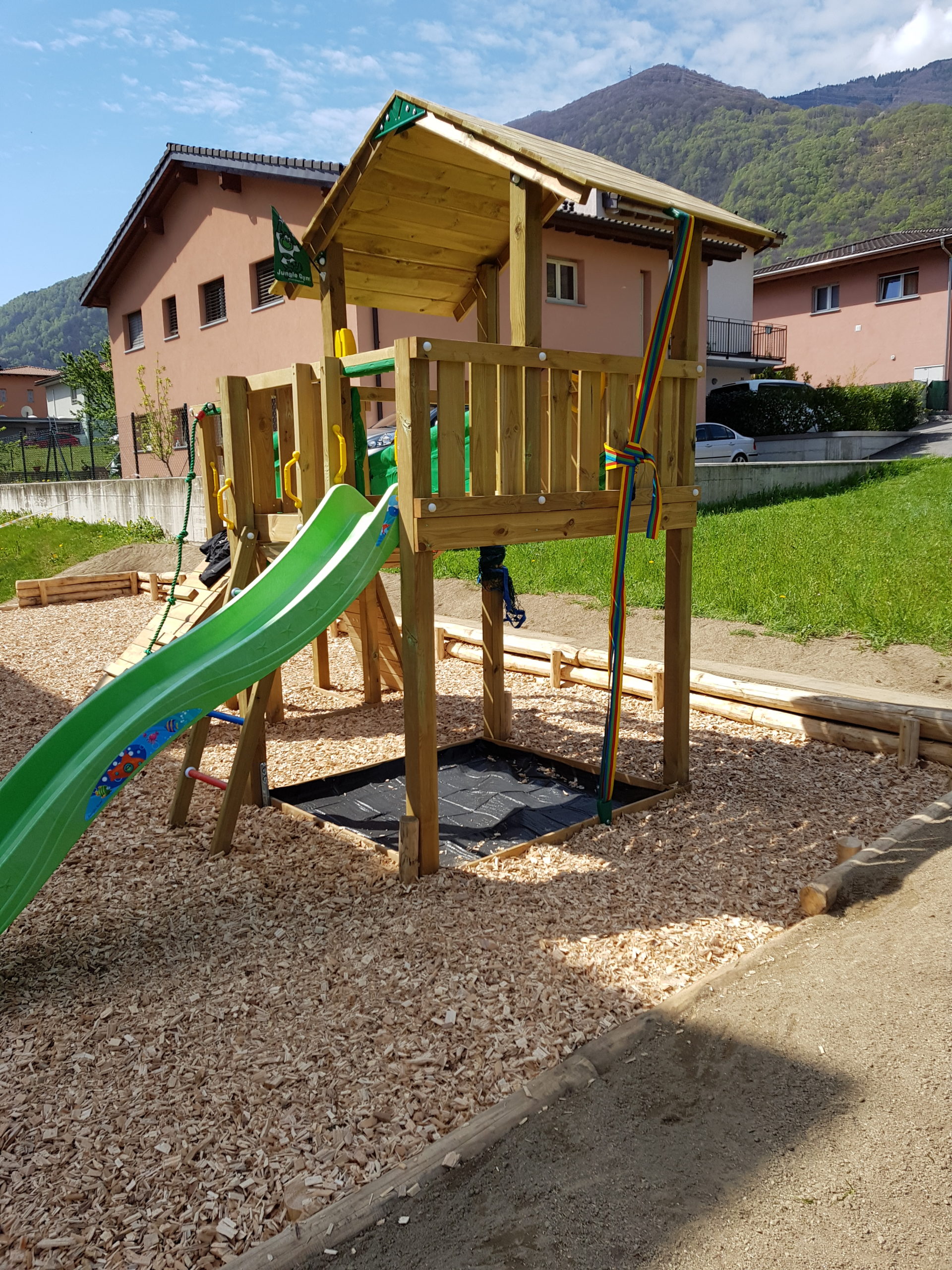 Area giochi in legno con scivolo verde